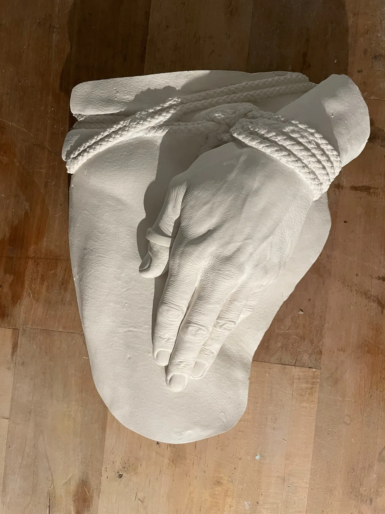 Plaster cast of two hands bound with rope