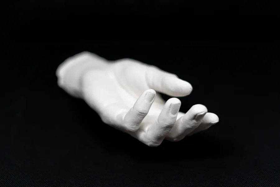 Plaster cast of an open hand on black