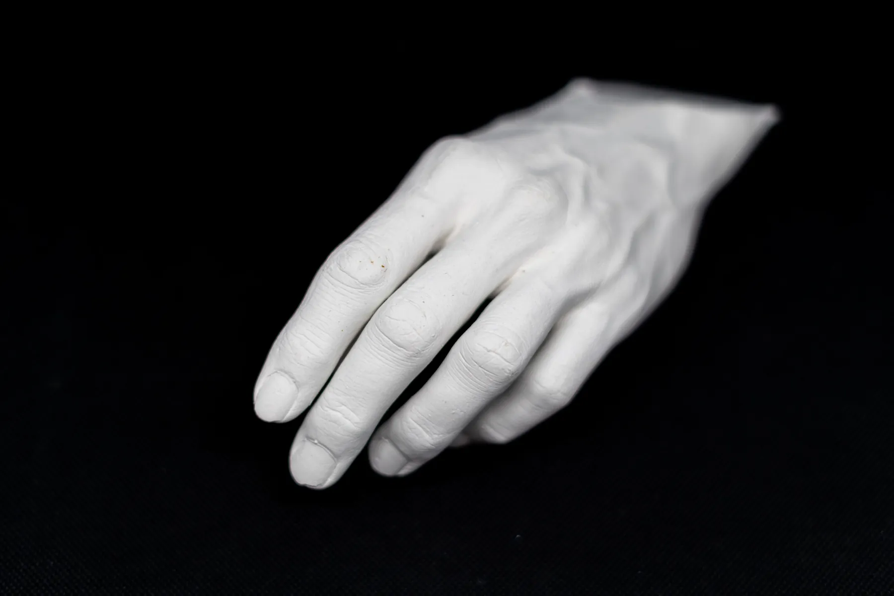 Plaster cast of a relaxed hand on black