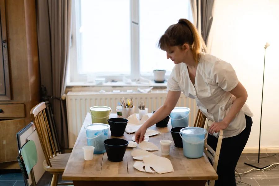 Brooke preparing the workshop table with buckets of alginate and plaster